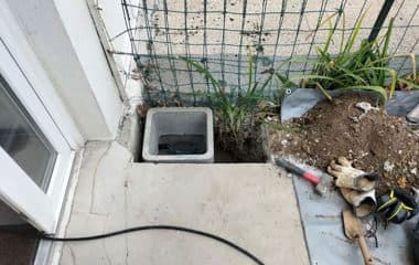 Regard télécom mis au jour et sa trappe reposée à niveau du sol
